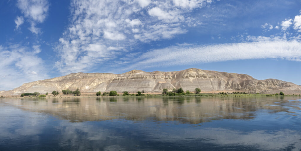 Panoramic view of the White Bluffs reflected in the Columbia River along the Hanford Reach National Monument, photographed by John Clement