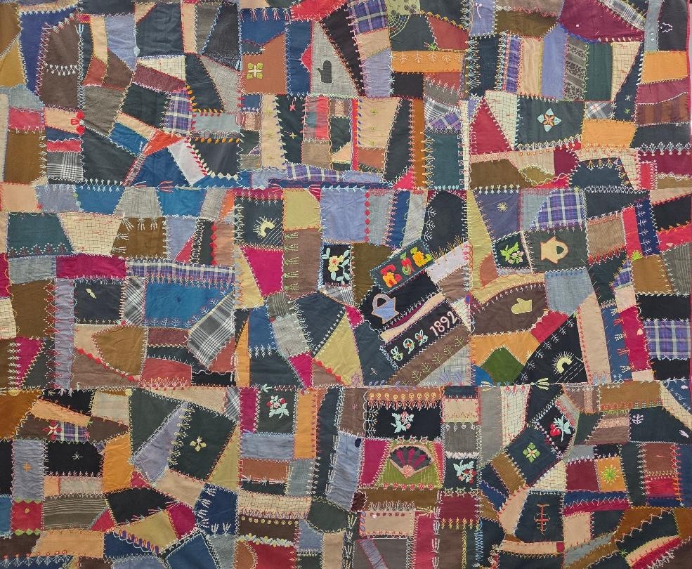 Lee Crazy Quilt with irregular multicolored fabric patches, decorative embroidery, and the date 1892 stitched near the center.